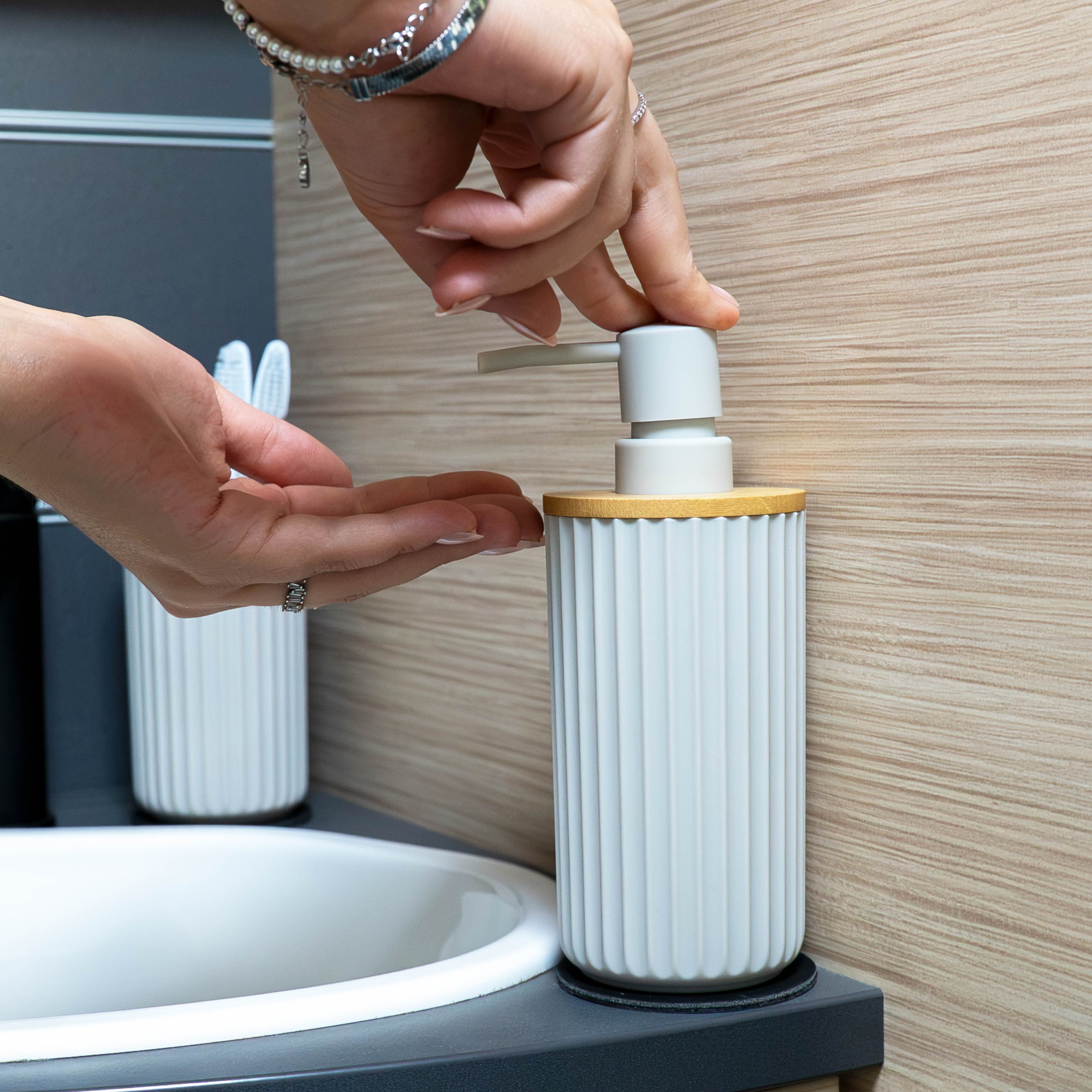 Magnetic soap dispenser and magnetic toothbrush cup including pads