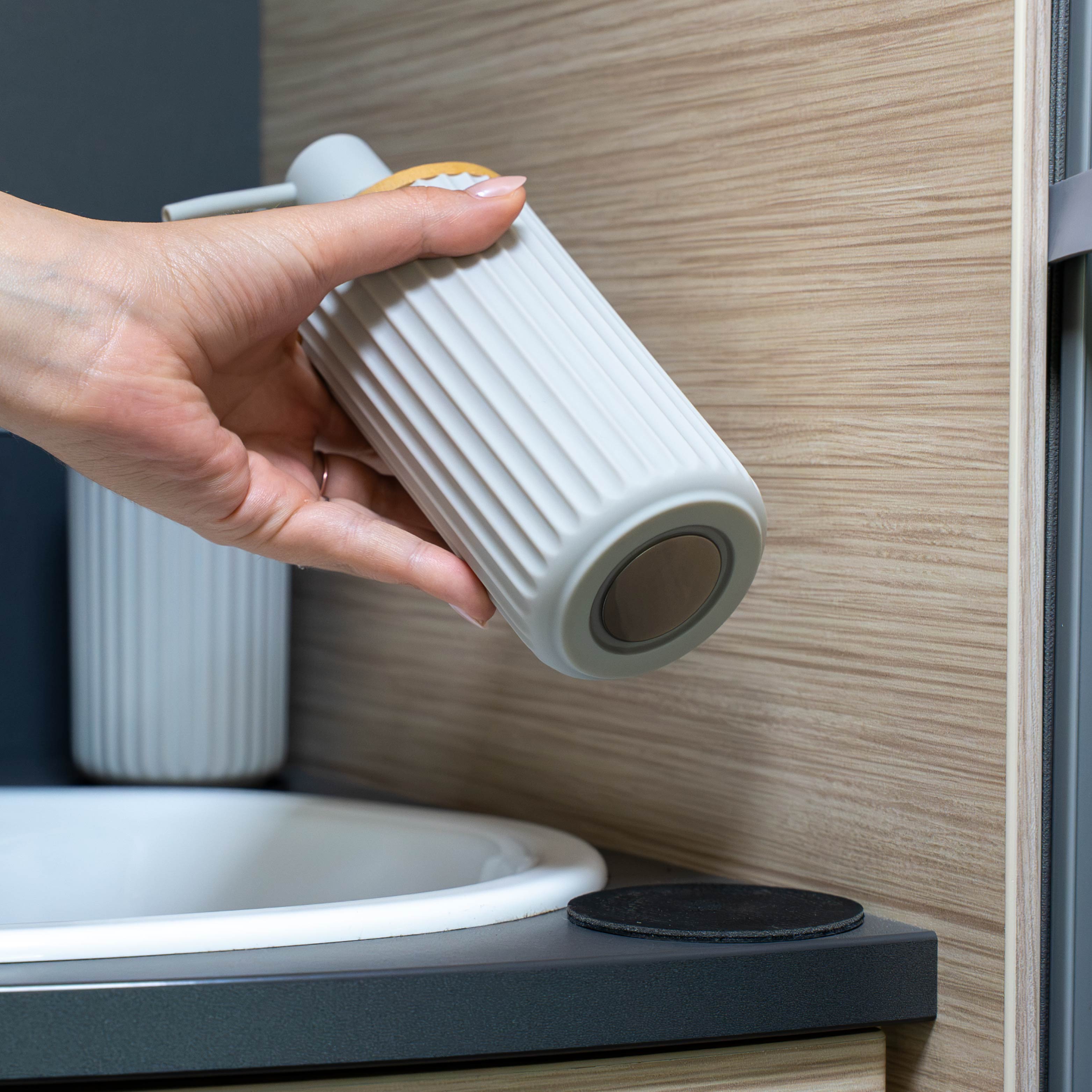 Magnetic soap dispenser and magnetic toothbrush cup including pads